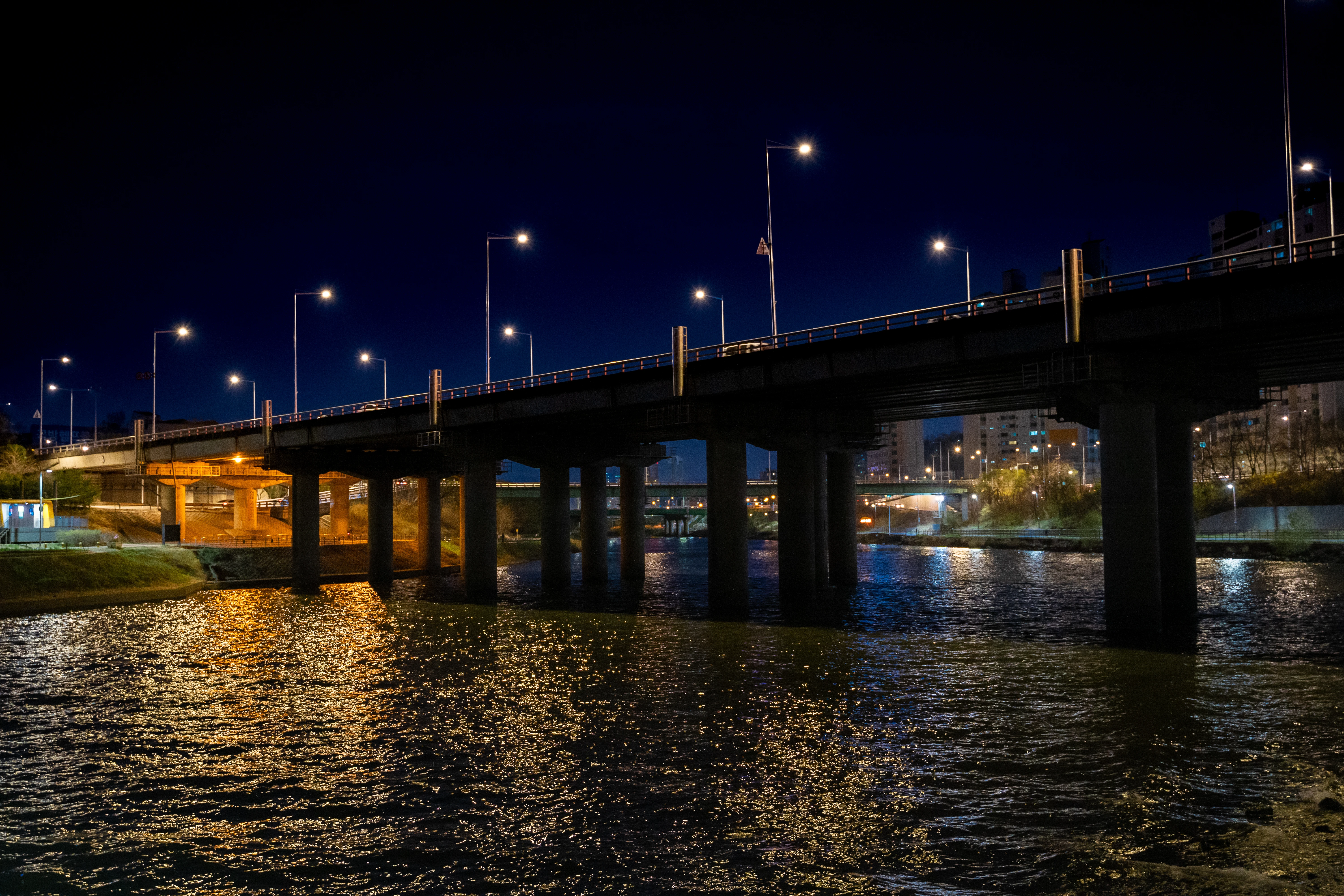 Illuminated Urban Bridge Over Rippling Night Waters